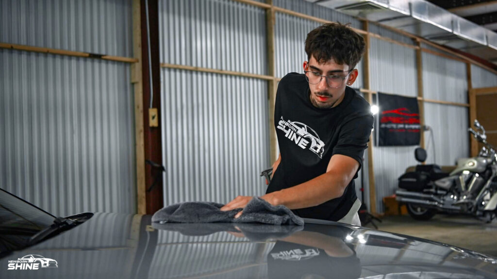 Josh from Newborn Shine wiping the Hood of a Grey Audi
